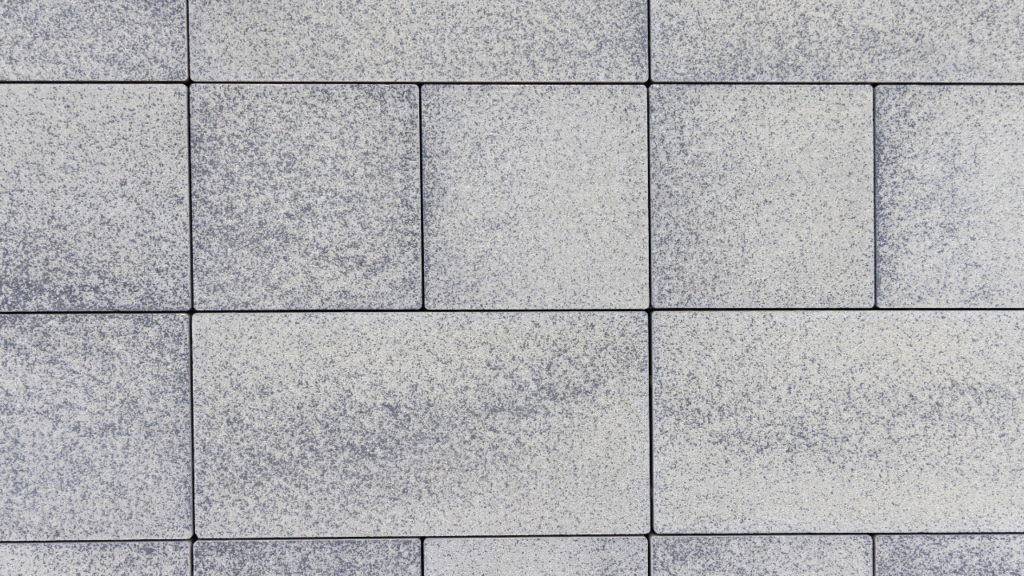 Strak gelegde grijze betontegels voor moderne tuinbestrating