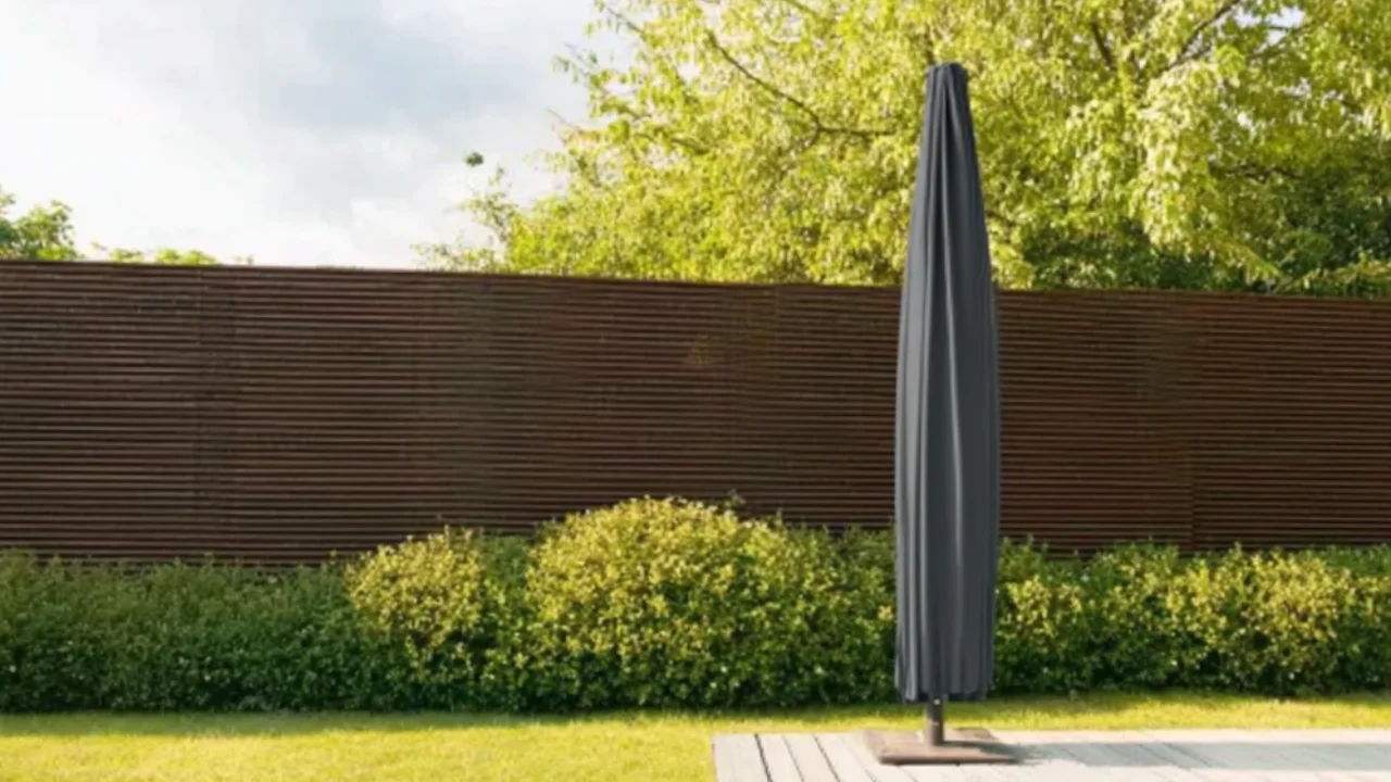 Parasol fermé dans une housse de protection noire dans le jardin